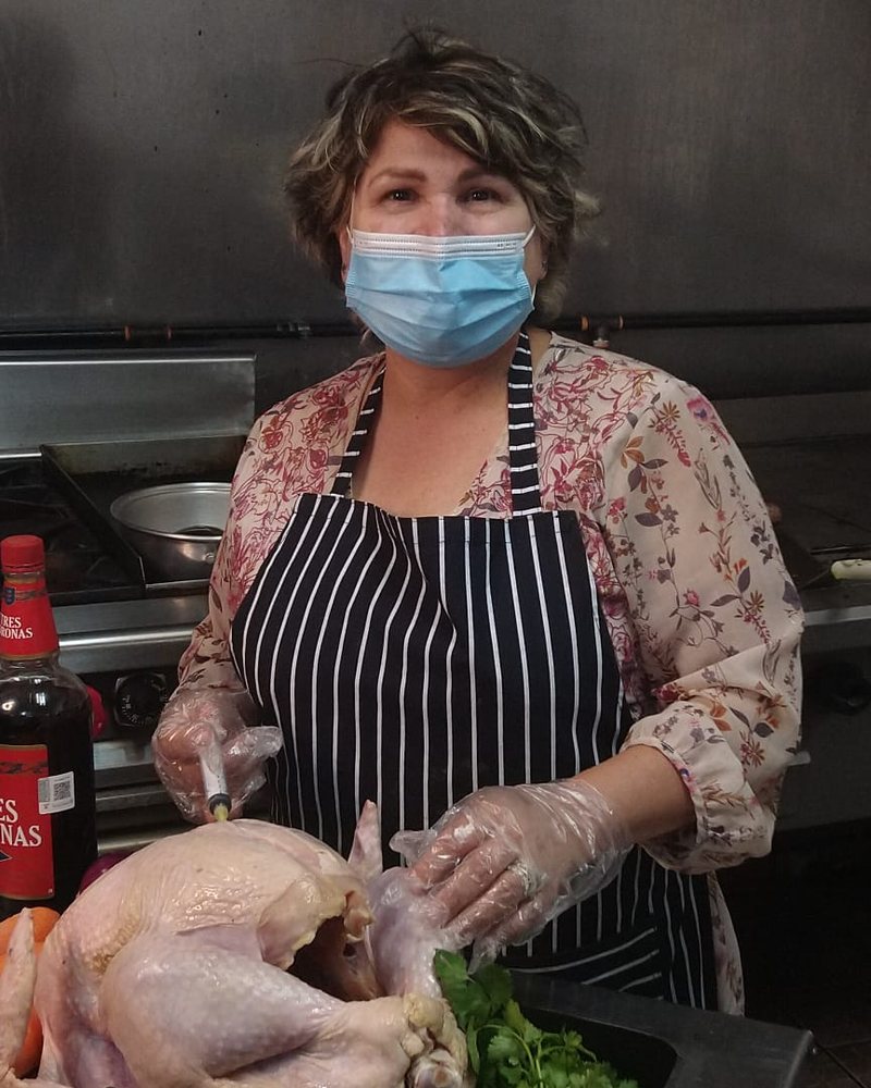 Cocinera de Tortería Los Azulejos preparando el pollo en la cocina del local